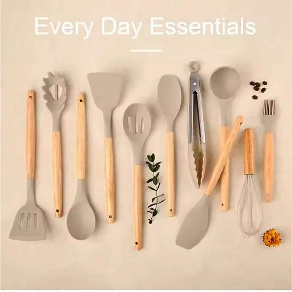 Flat lay of the khaki silicone utensil set with wooden handles arranged on a beige background with a leaf sprig