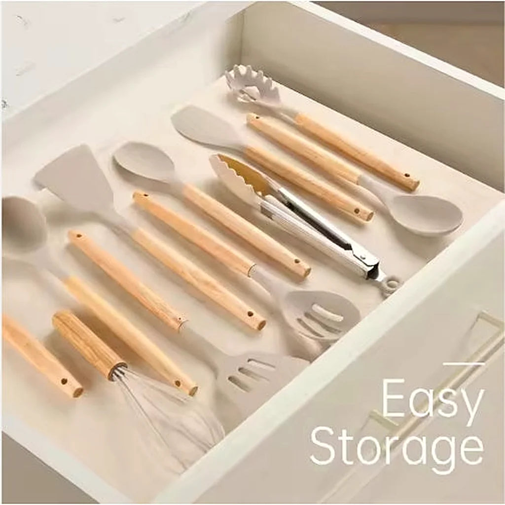 Silicone utensils with wooden handles stored neatly inside an open white kitchen drawer