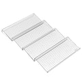 Four empty clear stepped spice rack tiers arranged in a row on a white background