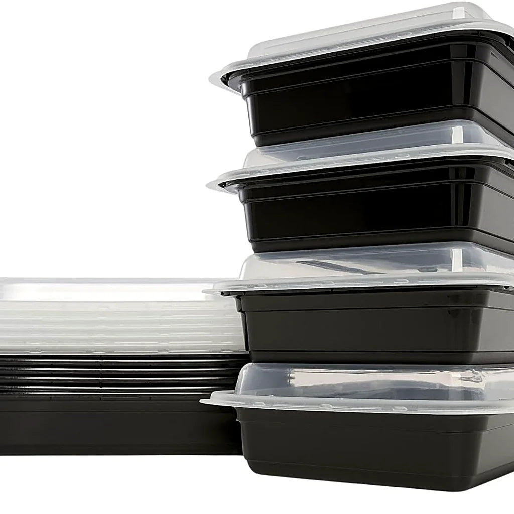 Stack of four black meal prep containers with clear lids beside a nested stack of empty containers and lids on white