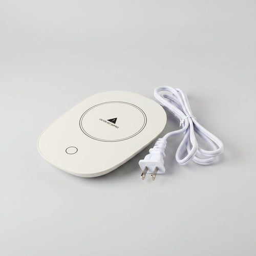White heating pad with a plug on a white background