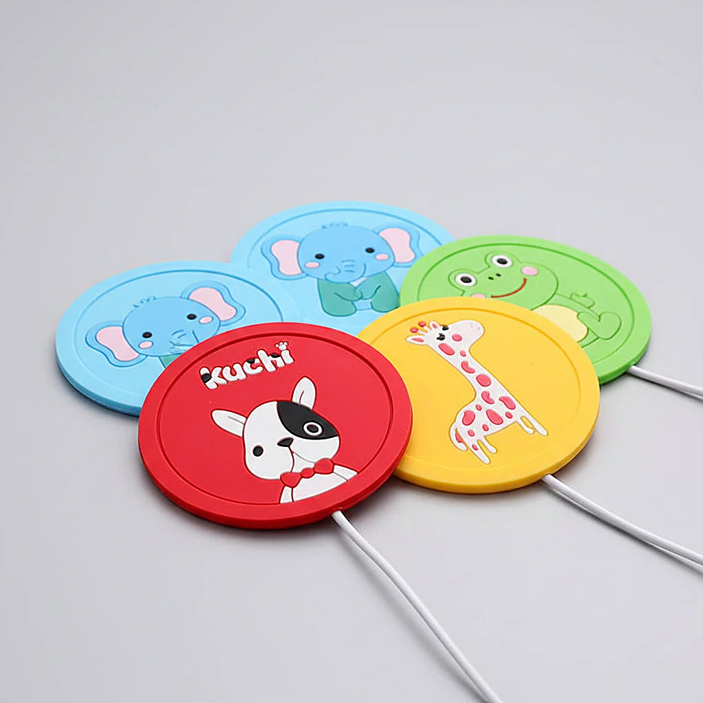 Five round USB warmer pads with cartoon animal designs fanned out on a gray surface