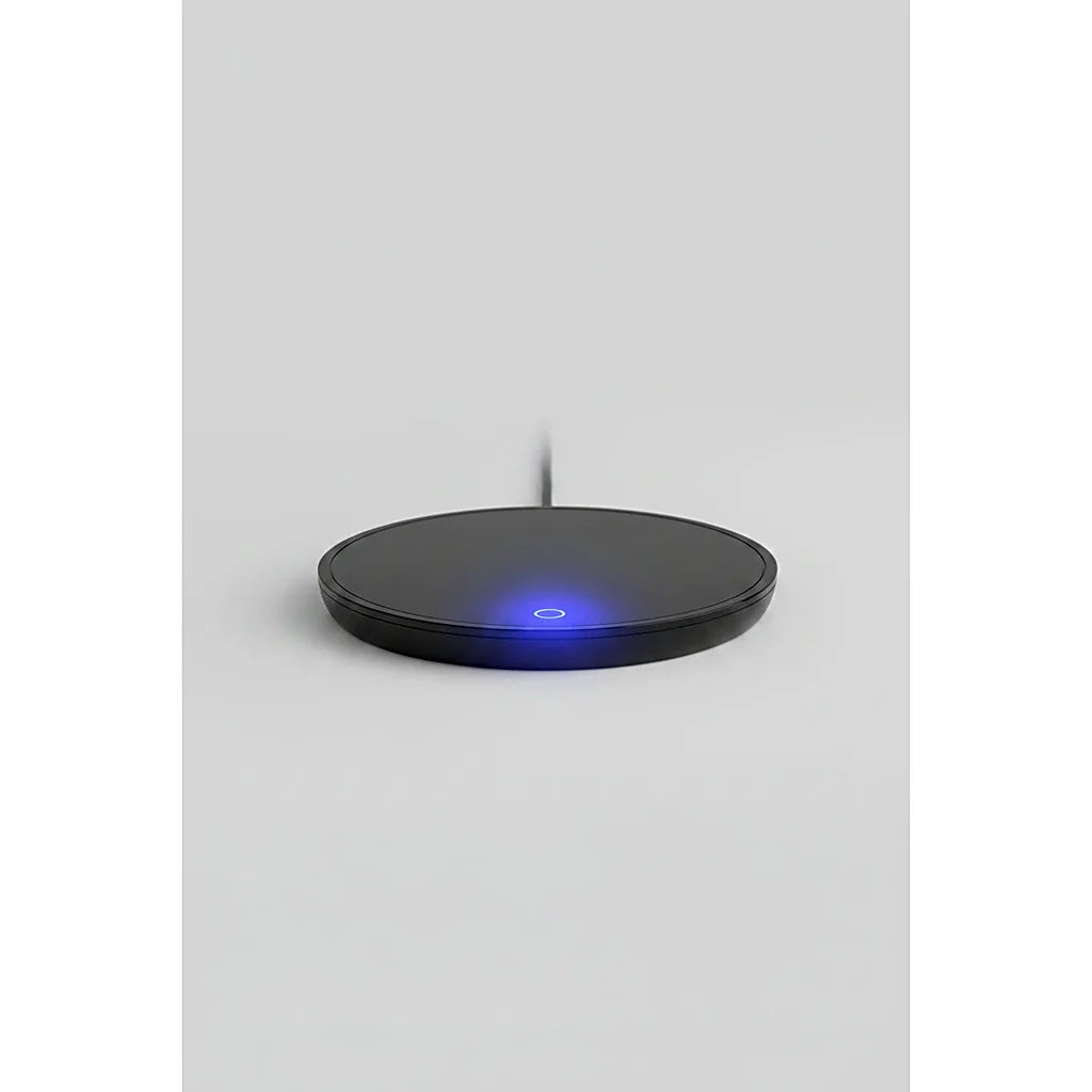 Black round mug warmer seen from the side, with a small blue indicator light glowing