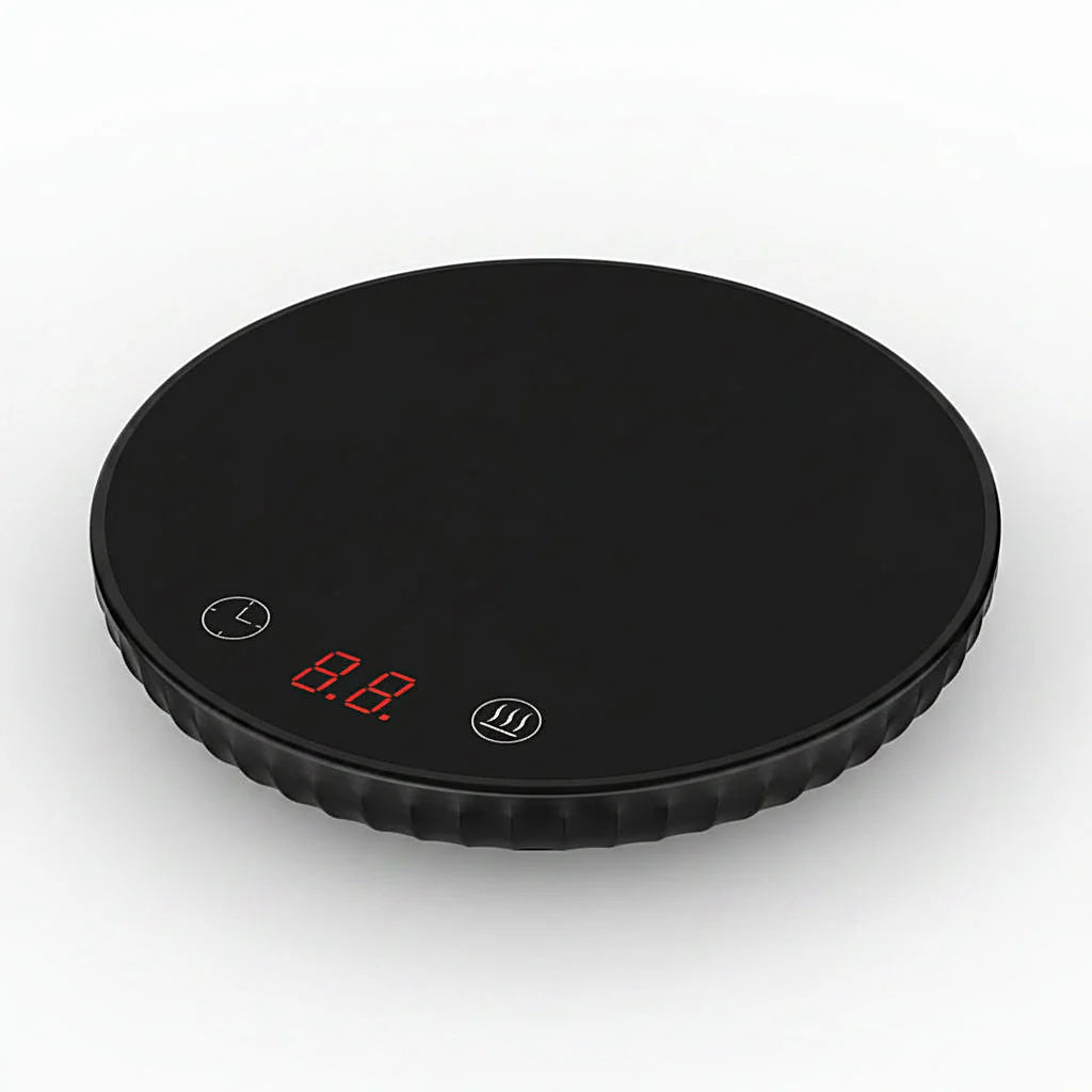 Black round mug warmer with a red digital display, viewed at an angle on a white background